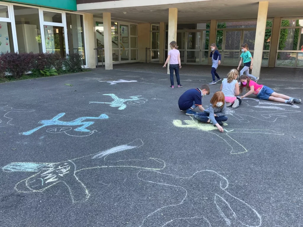 Kinder malen Kreide auf dem Schulhof