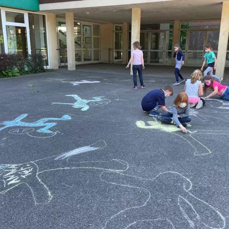 Kinder malen Kreide auf dem Schulhof